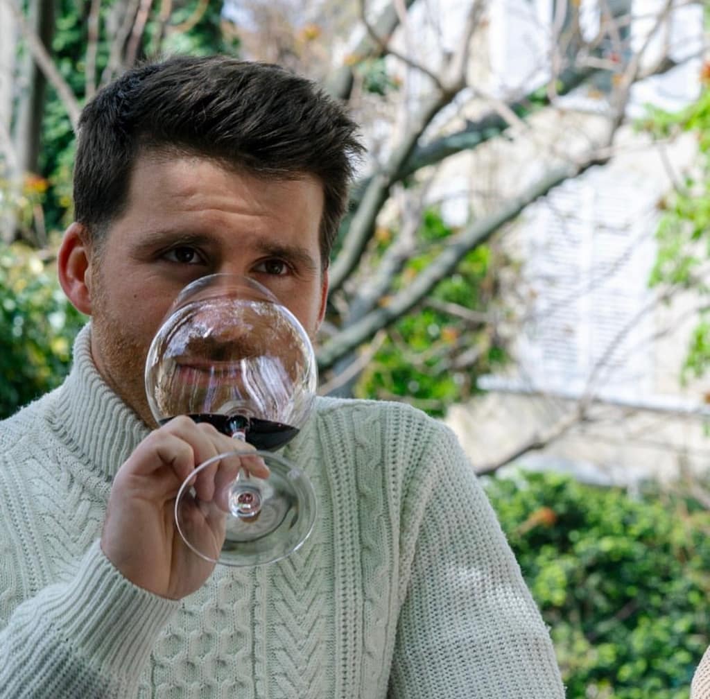 Image de Michel sentant un verre de vin rouge (deuxième étape de la dégustation)