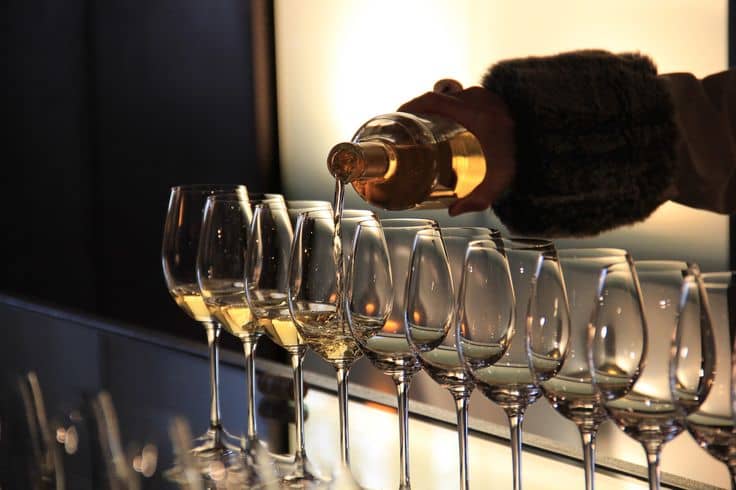 Image d'une personne servant des verres de vin blanc 