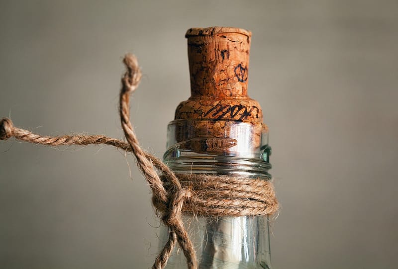 haut d'une bouteille de vin débouchonnée avec le bouchon posé dessus à l'envers et une ficelle attachée sur la partie haute de la bouteille
